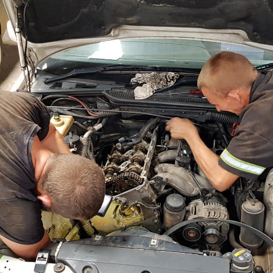 two mechanics working on car
